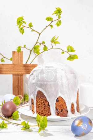 Photo for Easter orthodox catholic Christian  holiday background, with wooden cross symbol of religion, baking Easter cake with sugar icing, colored painted eggs and spring branches with blossoming leaves - Royalty Free Image