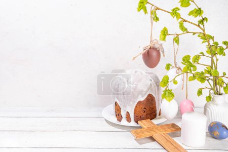 Photo for Easter orthodox catholic Christian  holiday background, with wooden cross symbol of religion, baking Easter cake with sugar icing, colored painted eggs and spring branches with blossoming leaves - Royalty Free Image