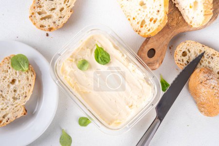 Homemade Vegan Butter, non-dairy creamy, plant based alternative butter with soy bean leave, and home baked bread on kitchen white table background