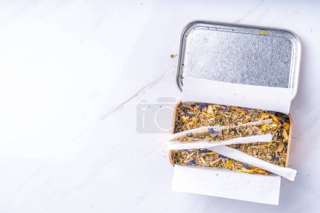 Alternative gesunde Berbal-Rauchermischung. Handgemachte Craft-Zigarette, Zubereitungsverfahren, mit Kräutermischung, Blättern und Blumen, mit Schachteln, Papier, auf weißem Hintergrund