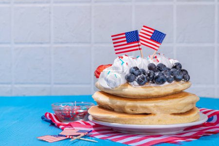 Feiertag 4. Juli Frühstück Pfannkuchen, Kuchen mit Schlagsahne und Beeren wie amerikanische Flagge. Hausgemachter patriotischer Brunch oder Snack, Idee für Party-Leckerbissen und Desserts