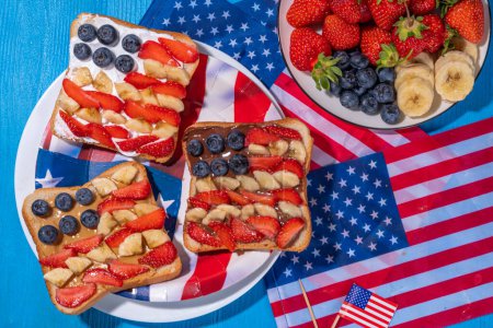  4. Juli Frühstückssandwiches, Feiertagssnack oder Brunch mit Erdnussbutter, Schokolade und Käseaufstrich, mit Erdbeeren, Blaubeeren und Banane in Form einer patriotischen amerikanischen Flagge