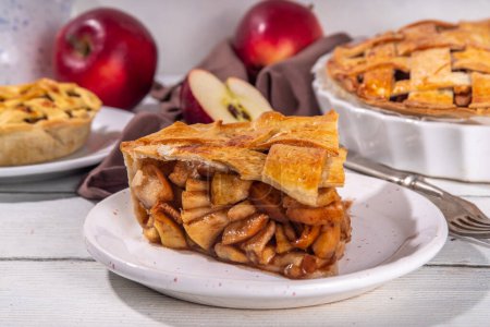 Traditioneller herbstlicher Apfelkuchen. Süßes Thanksgiving-Dinner, Herbstkuchen mit Äpfeln, Zimt, Nüssen und Karamell, mit Vanilleeis-Kugel, auf hölzernem, gemütlichem Hintergrund