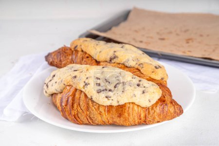 Crookie pâtissier français sucré tendance, un hybride de croissant avec des biscuits au beurre sucré avec des gouttes de chocolat garniture au four et glaçage Cookie Croissant (Le Crookie) Recette virale