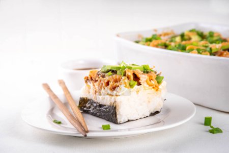 Filadelfia Sushi Bake Recipe cazuela hecha con arroz, queso crema, trucha de salmón, algas marinas, aguacate, salsa, cebolla verde. Servido con tostadas hojas de nori como taco