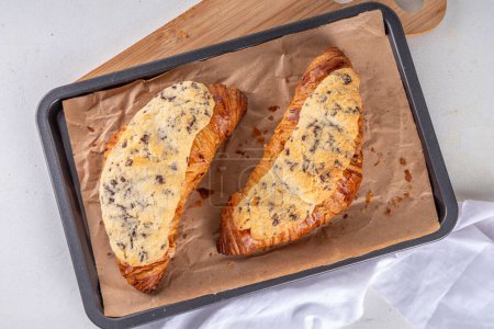 Crookie pâtissier français sucré tendance, un hybride de croissant avec des biscuits au beurre sucré avec des gouttes de chocolat garniture au four et glaçage Cookie Croissant (Le Crookie) Recette virale
