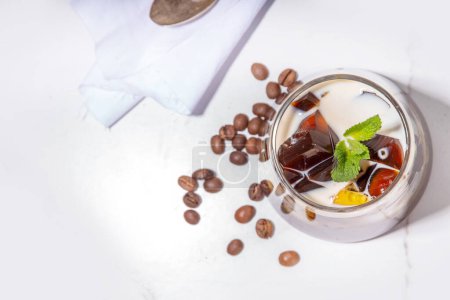 Kaffee-Gelee-Dessert mit starkem Espresso-Kaffee, Gelatine oder Agar und Schlagsahne. Asiatische kalte Kaffee-Bonbons kohii zerii kanten auf weißem Tischhintergrund Kopierraum
