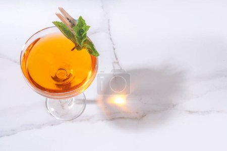 Un vieux cocktail d'alcool cubain. Boisson alcoolisée avec rhum blanc, citron vert, menthe, vin mousseux, boisson alcoolisée douce et amère sur fond blanc avec lumière dure et ustensiles de bar