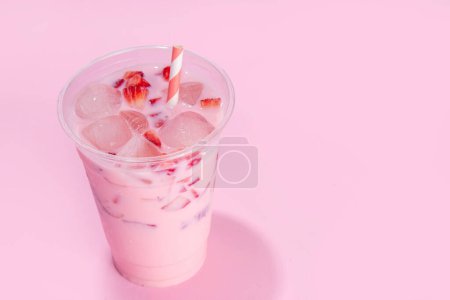 Strawberry coconut milkshake, frozen creamy cocktail drink with coconut milk and whipped sliced strawberries copy space