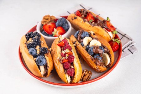Sweet summer fruit berry breakfast sweet hot dogs, dessert leftovers hot dogs with chocolate spread, various fruit, blueberry, raspberry, strawberry, blackberry, nuts