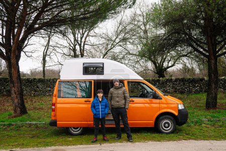 Photo for Portrait of the child and the adult next to the camper van. - Royalty Free Image