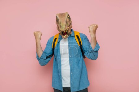 Photo for Man with backpack and lizard mask on pink background. - Royalty Free Image