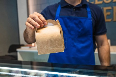 Téléchargez les photos : Serveur homme livraison de plats à emporter dans les petites entreprises. - en image libre de droit