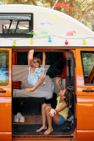 Téléchargez les photos : Les enfants heureux s'amusent lors d'une merveilleuse journée de camping. Concept Vanlife. - en image libre de droit