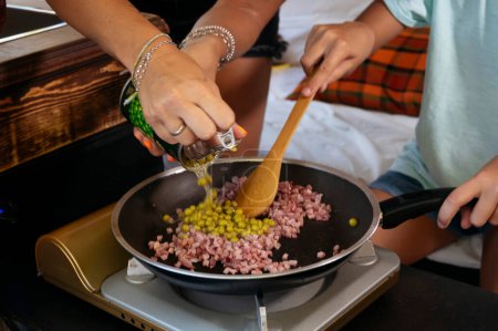 Téléchargez les photos : La mère prépare la nourriture lors d'une merveilleuse journée au camp. Concept de vie Van. - en image libre de droit
