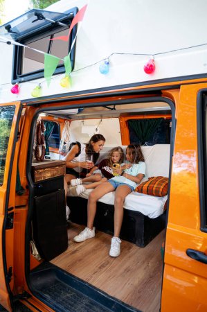Téléchargez les photos : Famille utilisant le smartphone dans une merveilleuse journée de camping. - en image libre de droit