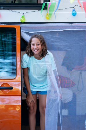 Photo for The girl has fun on a wonderful day at camp. Van life concept. - Royalty Free Image