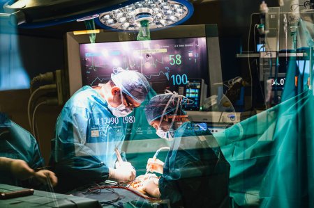 Foto de Photographic double exposure of the doctors working in the operating room. - Imagen libre de derechos