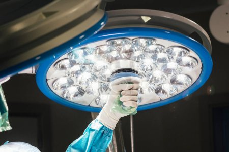 Foto de La mano del doctor coloca la lámpara para la operación - Imagen libre de derechos