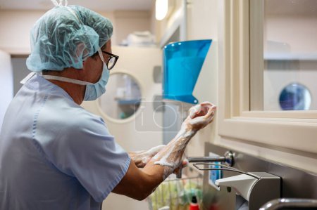 Téléchargez les photos : Docteur se lave les mains dans la salle d'opération. - en image libre de droit