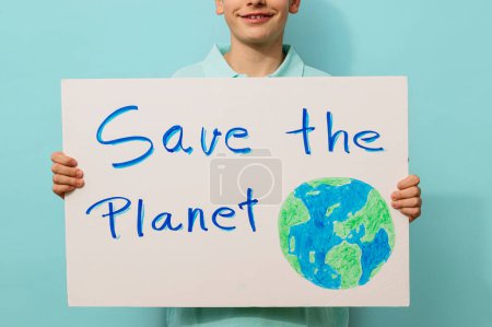 Photo for Young activist boy holds a sign that says save the planet. - Royalty Free Image