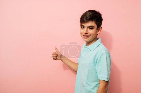 Foto de Joven haciendo dedo hacia arriba gesto positivo en el estudio. - Imagen libre de derechos