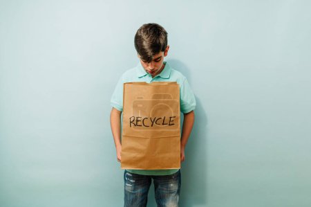 Téléchargez les photos : Recyclage des jeunes garçons avec sac en papier en studio. - en image libre de droit