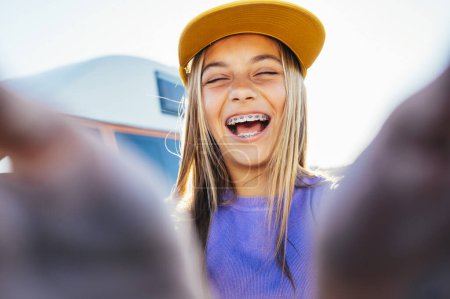 Photo for Beautiful teen girl taking selfies in a yellow cap and bracket on her teeth. - Royalty Free Image