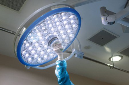 Foto de La mano del cirujano moviendo las lámparas en el quirófano del hospital. concepto de salud bombilla de luz - Imagen libre de derechos