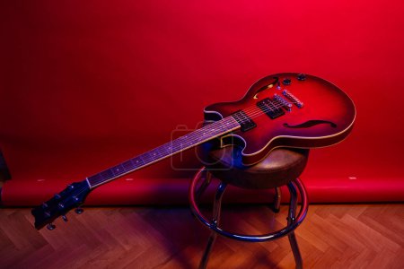 Téléchargez les photos : Une guitare électrique sur fond rouge. - en image libre de droit