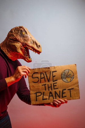 Photo for Man with lizard head in studio holding a cardboard sign that says SAVE THE PLANET - Royalty Free Image