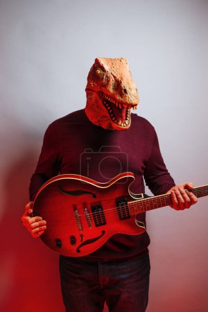 Foto de Hombre con cabeza de lagarto y guitarra eléctrica en el estudio. - Imagen libre de derechos