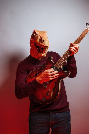 Foto de Hombre con cabeza de lagarto y guitarra eléctrica en el estudio. - Imagen libre de derechos