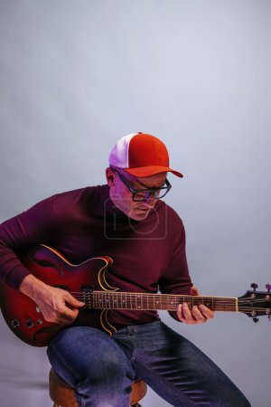 Téléchargez les photos : Homme adulte jouant de la guitare en studio. - en image libre de droit