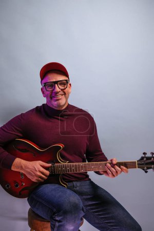 Photo for Adult man playing guitar in studio. - Royalty Free Image