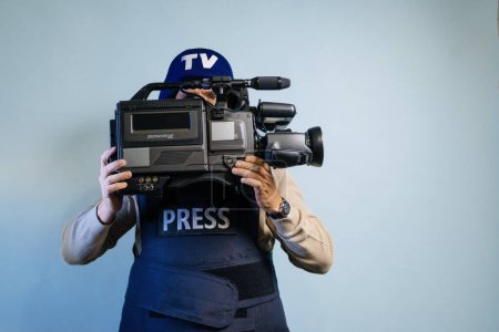 Photo for Reporter in bulletproof vest holding a video camera - Royalty Free Image