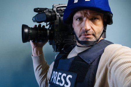 Photo for Reporter in bulletproof vest holding a video camera - Royalty Free Image