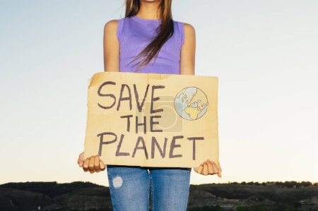 Téléchargez les photos : Belle adolescente tenant une pancarte qui dit SAVE THE PLANET. - en image libre de droit