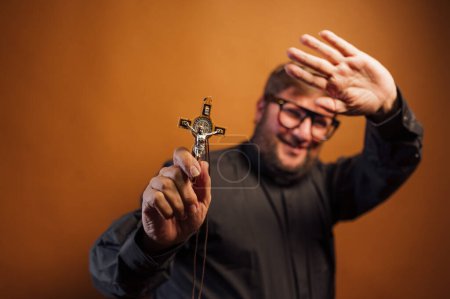 Téléchargez les photos : Portrait d'un prêtre exorciste avec crucifix et chemise noire. - en image libre de droit