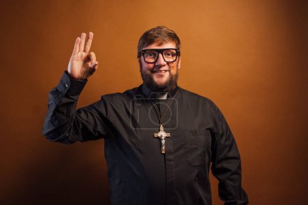 Téléchargez les photos : Portrait d'un prêtre avec crucifix faisant des gestes de main. - en image libre de droit