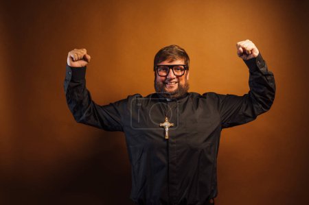 Photo for Portrait of a priest with a crucifix showing his arms as a symbol of strength. - Royalty Free Image