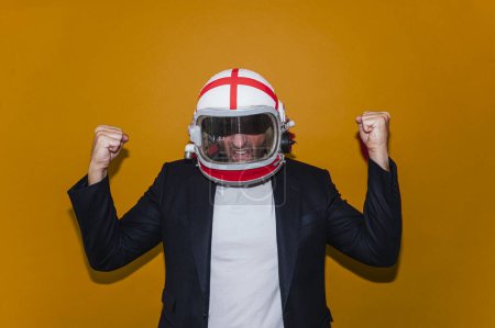 Téléchargez les photos : Homme d'affaires avec casque astronaute célébrant les poings enflammés - en image libre de droit
