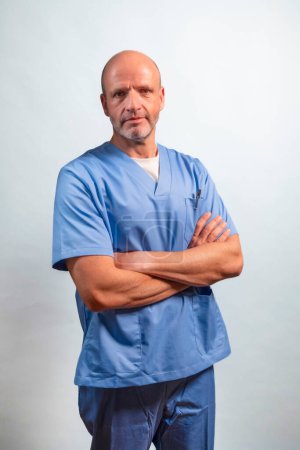 Téléchargez les photos : Portrait d'un physiothérapeute en robe bleu clair regardant la caméra en studio. - en image libre de droit