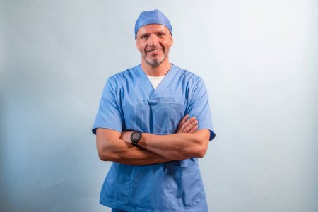 Téléchargez les photos : Portrait d'un physiothérapeute en robe bleu clair regardant la caméra en studio. - en image libre de droit
