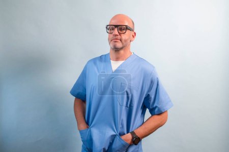 Photo for Portrait of a physiotherapist in light blue gown looking at camera in studio. - Royalty Free Image