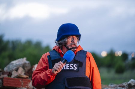 Téléchargez les photos : Journaliste de presse en gilet pare-balles tenant un microphone. - en image libre de droit