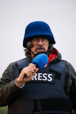 Foto de Periodista de prensa en chaleco antibalas con micrófono. - Imagen libre de derechos