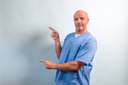 Photo for Portrait of a physiotherapist in light blue gown pointing at a side. - Royalty Free Image