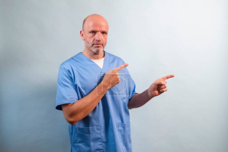 Photo for Portrait of a physiotherapist in light blue gown pointing at a side. - Royalty Free Image