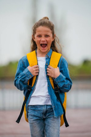 Photo for A teenage girl going to school looking at the camera with a backpack. - Royalty Free Image